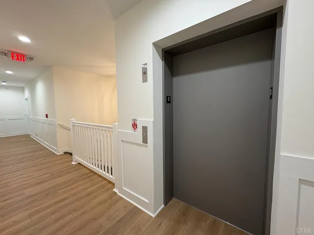 a view of a hallway with wooden floor and stairs