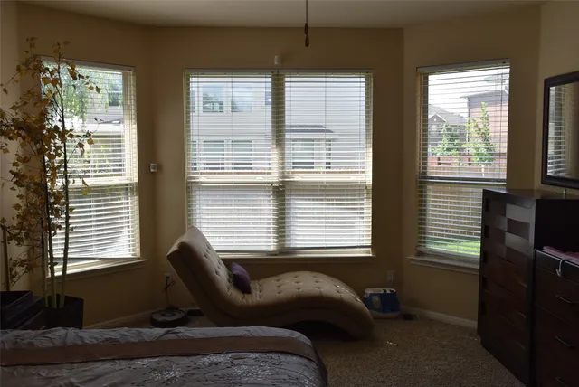 a bedroom with a window and a chair