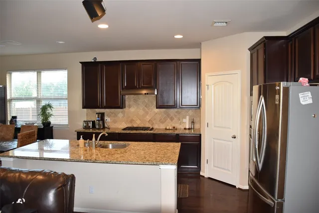 a kitchen with stainless steel appliances granite countertop a refrigerator and a sink