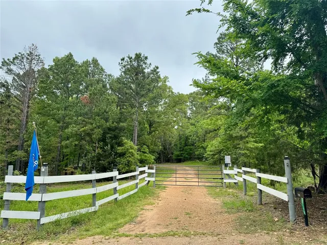 a view of a swimming pool with a bench and trees around