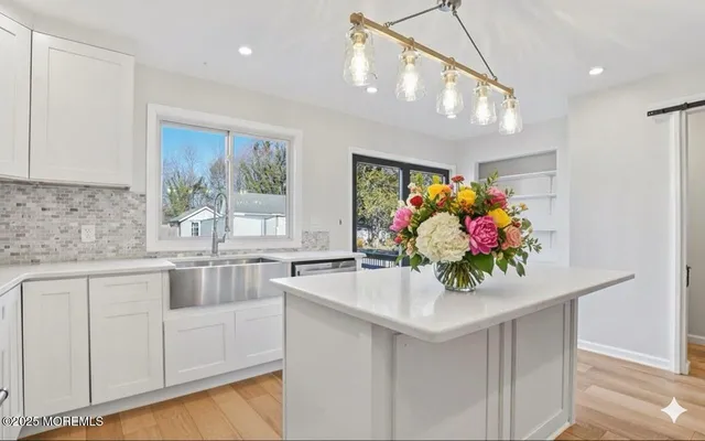 a kitchen with stainless steel appliances kitchen island granite countertop a white cabinets and granite counter tops