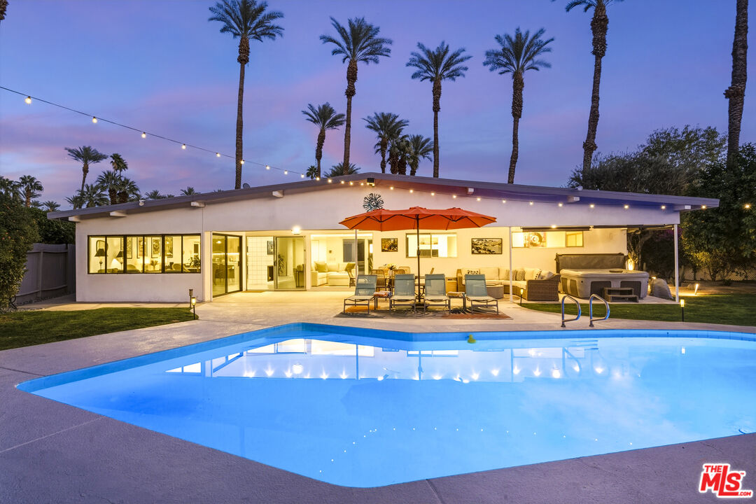 37223 Ferber Drive Rancho Mirage, CA 92270 - Photo 2 of 48 a view of a swimming pool with a table and chairs under an umbrella