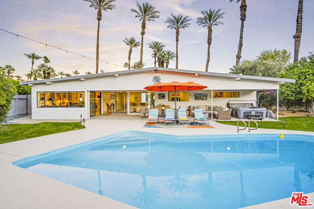 37223 Ferber Drive Rancho Mirage, CA 92270 - Photo 32 of 48 a view of an swimming pool with a lawn chairs under an umbrella