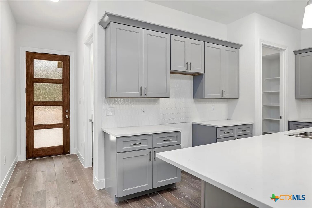 155 North Rip Ford Road, Unit B Spring Branch, TX 78070 - Photo 5 of 17 a kitchen with stainless steel appliances a white cabinets and wooden floor