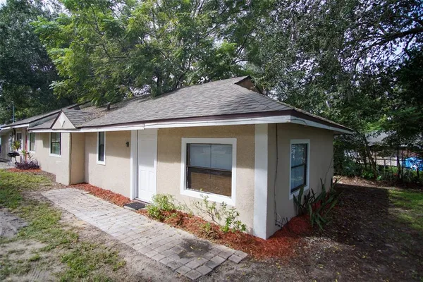 a view of a house with a yard and large tree