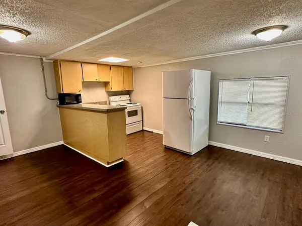 a kitchen with stainless steel appliances wooden floors and white cabinets