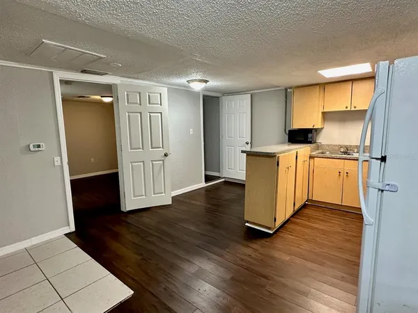 a kitchen with stainless steel appliances granite countertop a refrigerator a sink dishwasher and a stove with wooden floor