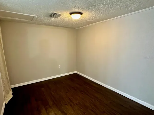 a view of an empty room with wooden floor