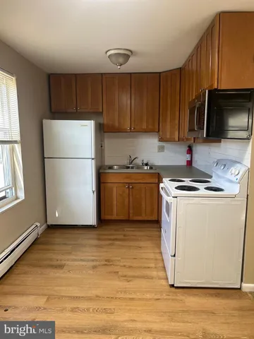 a kitchen with a sink a refrigerator and a microwave