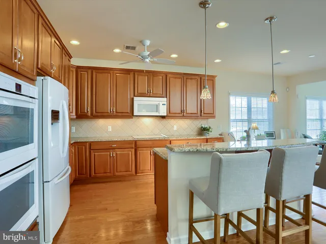 a kitchen with kitchen island granite countertop wooden cabinets and stainless steel appliances