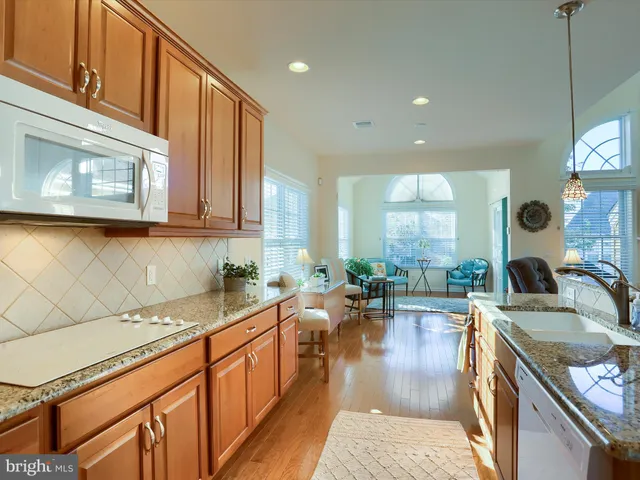 a kitchen with a sink a counter top space cabinets and stainless steel appliances