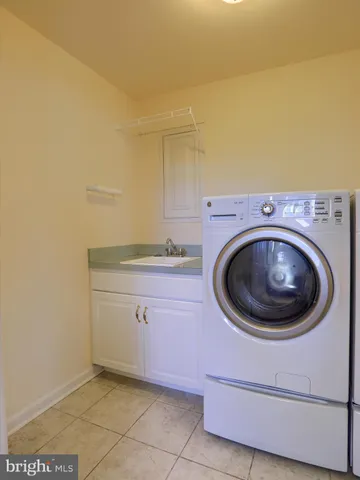 a utility room with sink dryer and washer