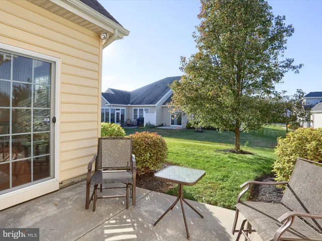 a view of a chair and table in backyard of the house