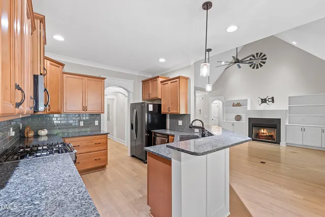 a kitchen with granite countertop a stove a sink and a refrigerator