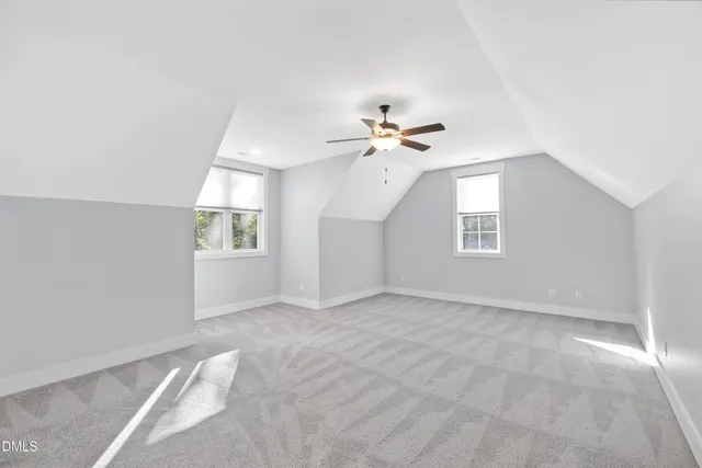 an empty room with windows and chandelier fan