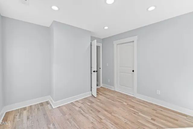 a view of an empty room with wooden floor