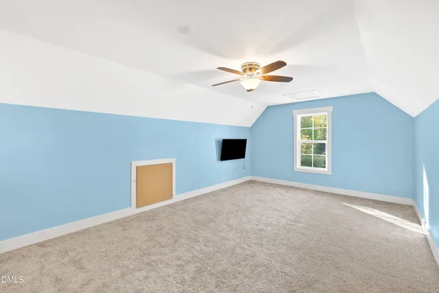 an empty room with windows and ceiling fan