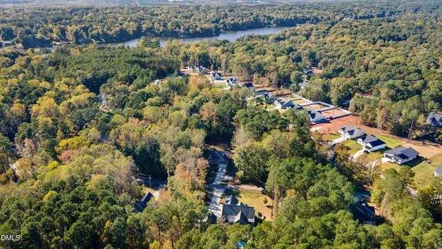 an aerial view of residential houses with outdoor space and trees