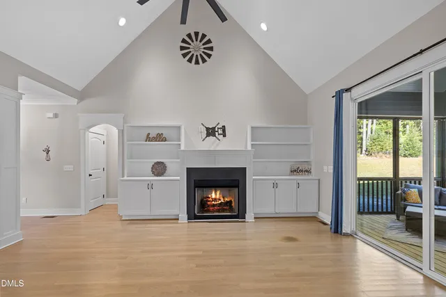 a view of an empty room with a fireplace and window