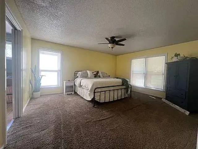 a spacious bedroom with a bed and a chandelier