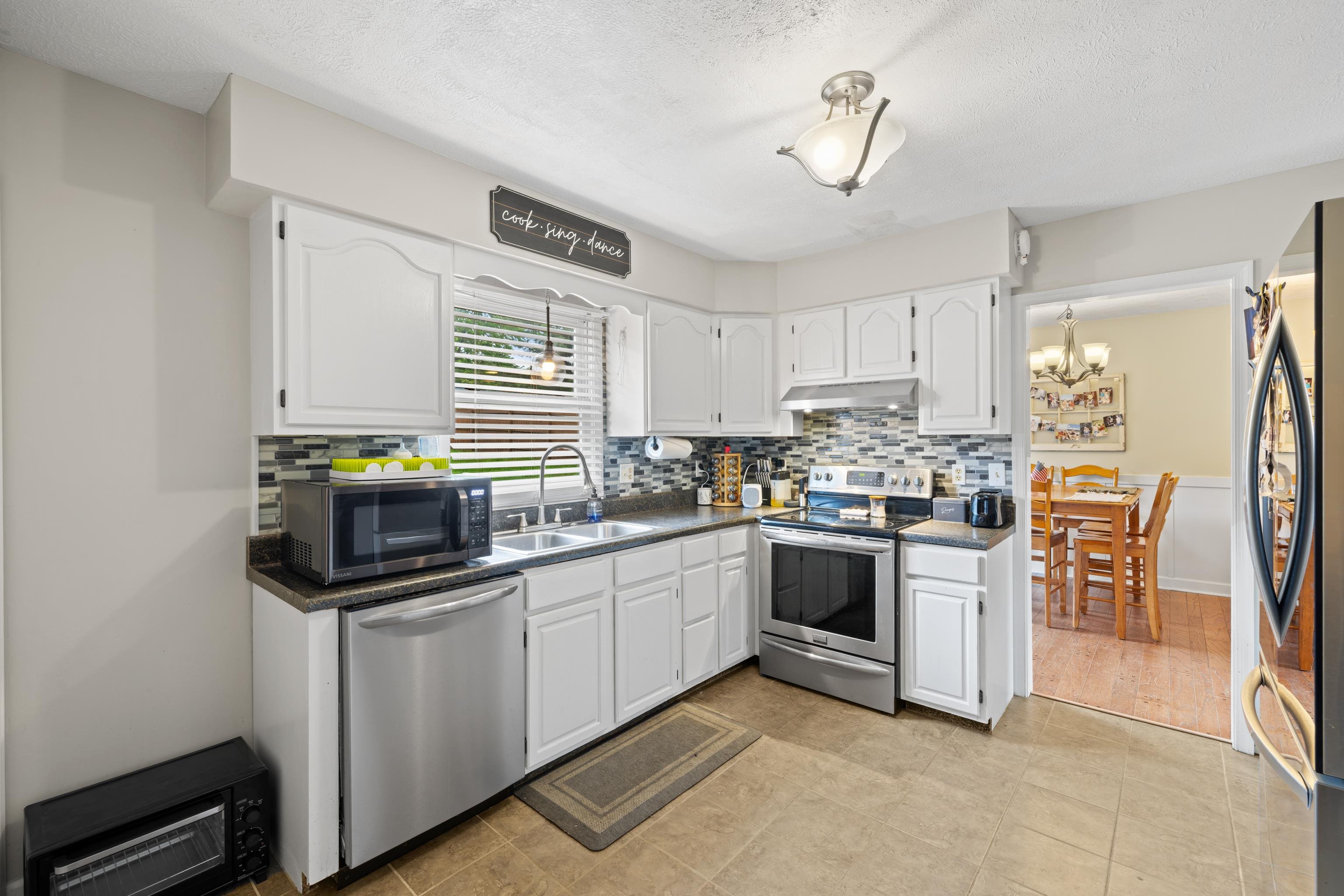 701 Horseshoe Circle Stuarts Draft, VA 24477 - Photo 8 of 70 a kitchen with granite countertop stainless steel appliances a stove top oven a sink a dining table and chairs