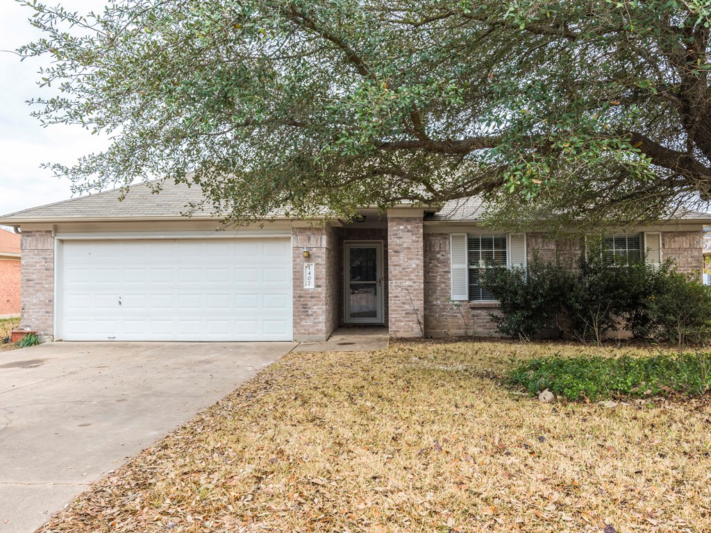 1407 Ashley Drive Round Rock, TX 78665 - Photo 1 of 1 a front view of a house with a garden