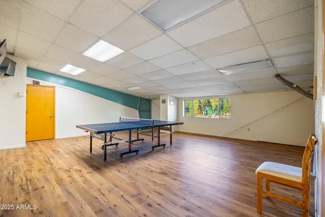 a view of game room with window and wooden floor
