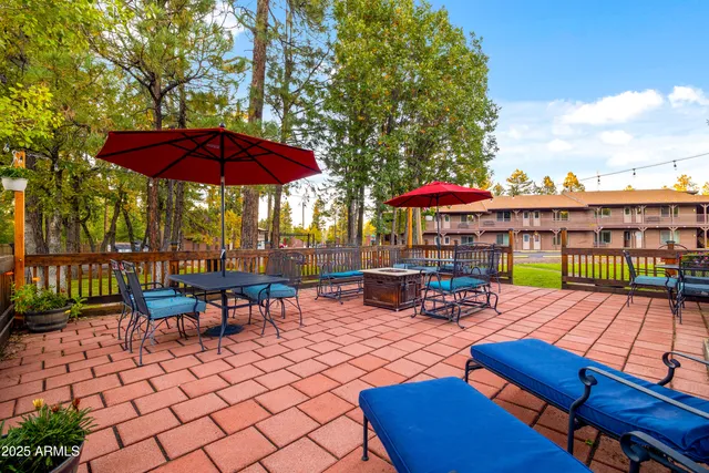 a view of a patio with a table and chairs under an umbrella