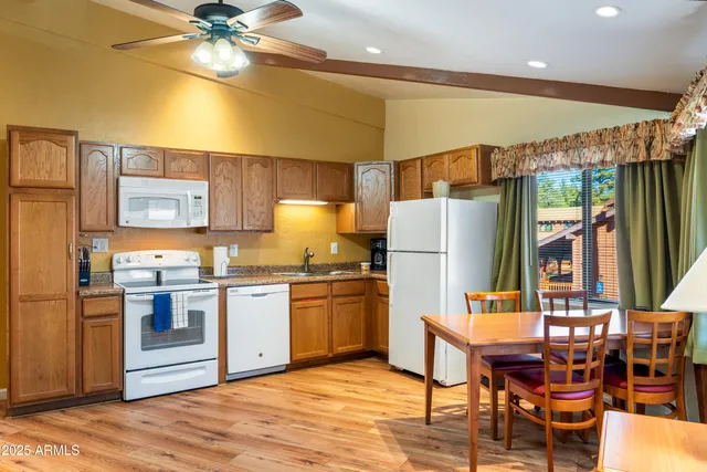 a kitchen with stainless steel appliances granite countertop a stove refrigerator and a dining table