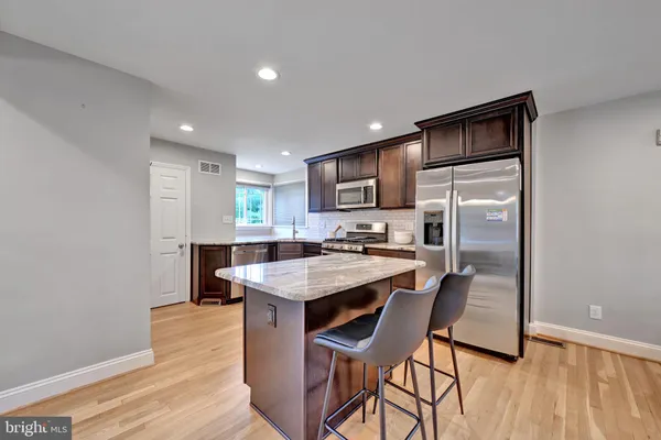 a kitchen with a table chairs refrigerator and microwave