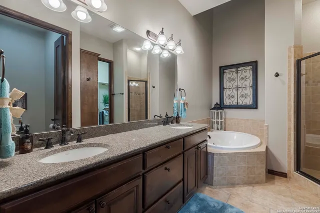 a bathroom with a granite countertop sink a toilet a mirror and bathtub