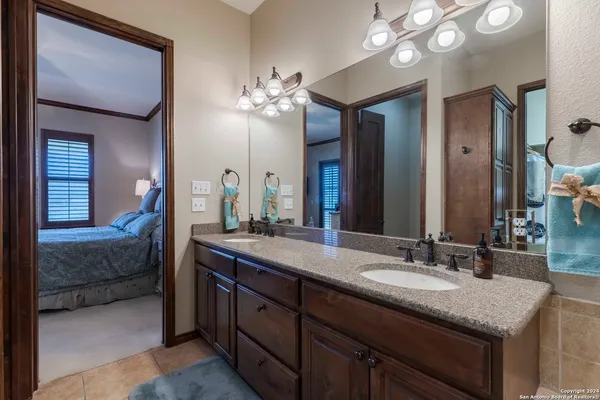 a en suite bathroom with a granite countertop double vanity sink and a mirror