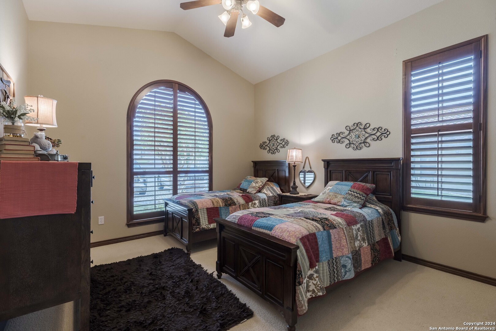 3801-15 Club House Road, Unit 15 Kerrville, TX 78028 - Photo 19 of 26 a bedroom with a bed a fireplace and a chandelier