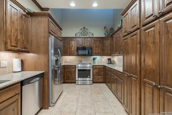 a kitchen with stainless steel appliances granite countertop a refrigerator and a sink