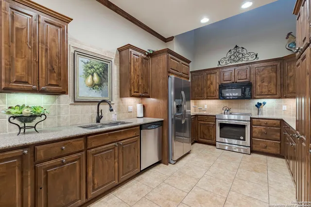 a kitchen with stainless steel appliances granite countertop a refrigerator and a stove top oven