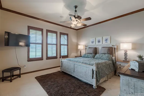 a bedroom with a bed chandelier and a window