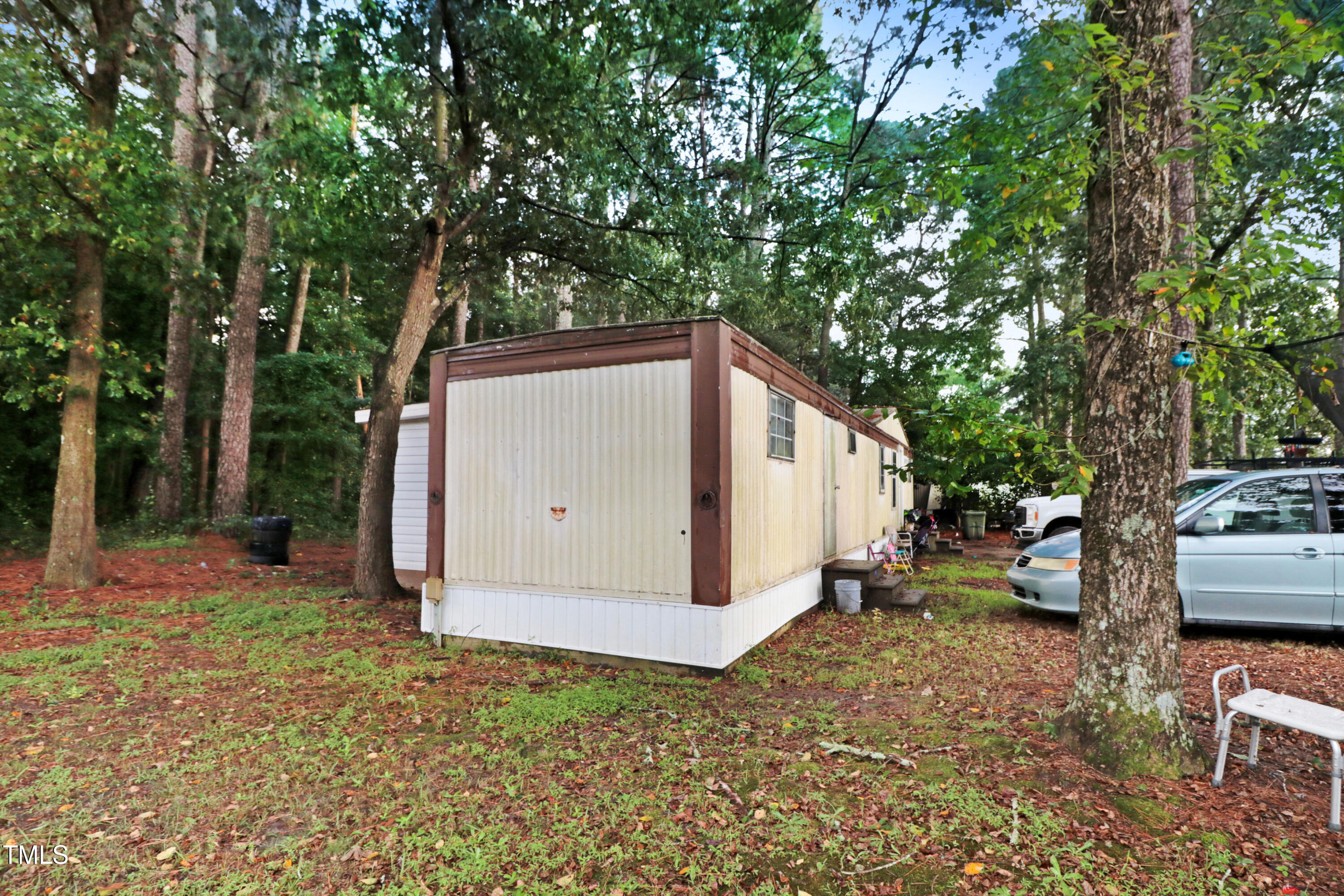 2037 Old Rock Quarry Road Princeton, NC 27569 - Photo 10 of 25 a backyard of a house with lawn chairs and a large tree