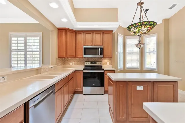 a kitchen with kitchen island granite countertop a stove a sink and a microwave