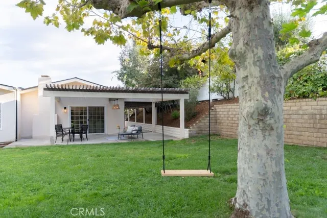 a view of a house with a yard and sitting area