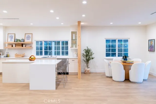 a living room with a large window wooden floor and white table