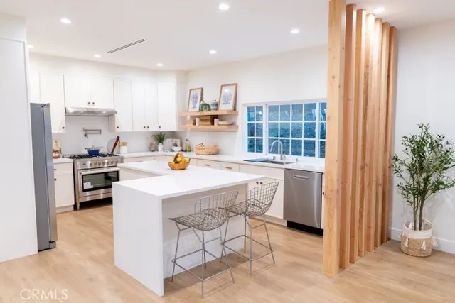 a kitchen with a sink a refrigerator and wooden cabinets