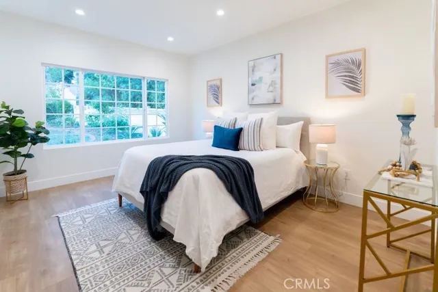 a bedroom with a bed lamp and a potted plant