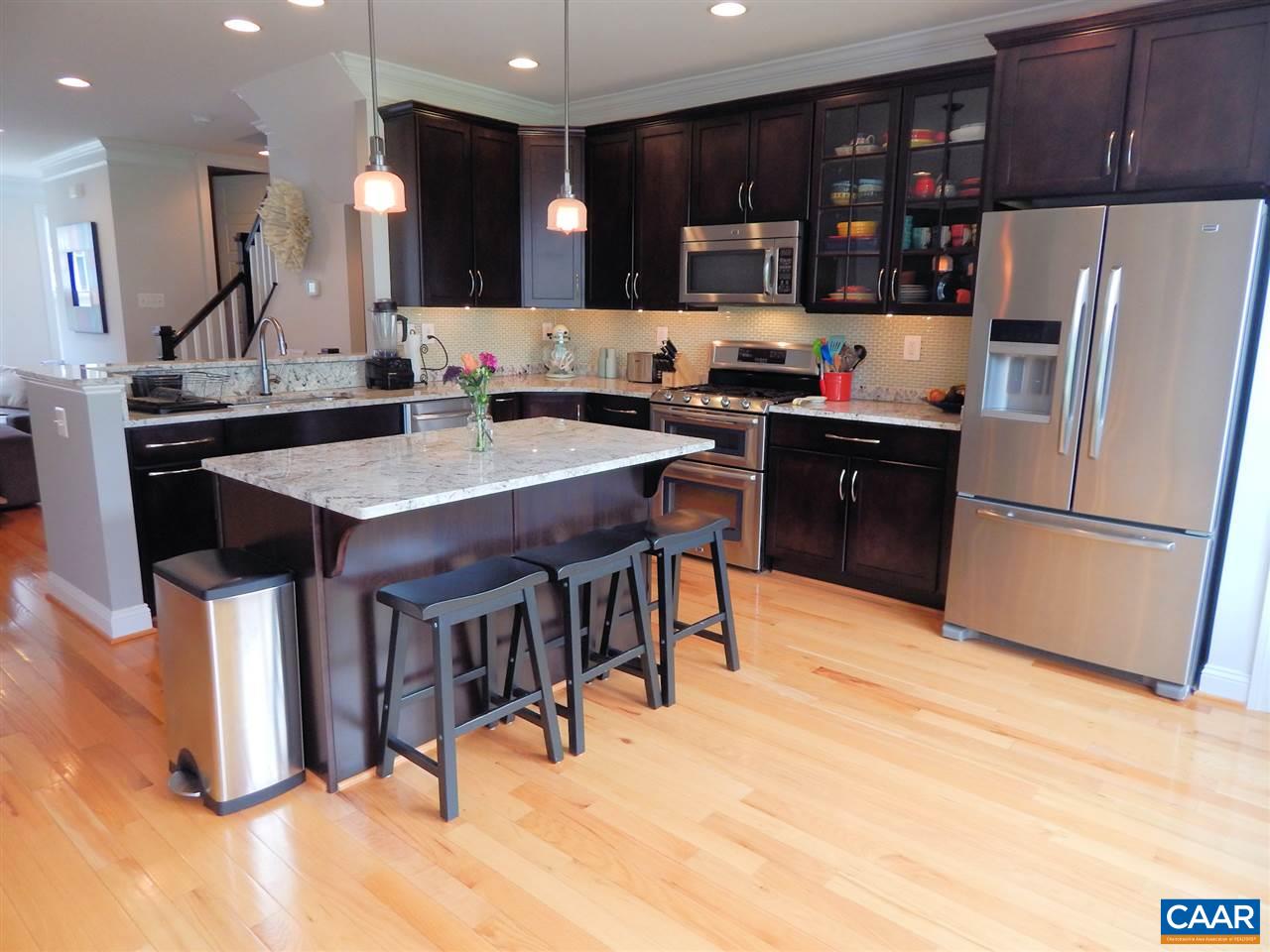 2055 Avinity Loop Charlottesville, VA 22902 - Photo 8 of 28 a kitchen with stainless steel appliances kitchen island granite countertop a refrigerator a sink a stove and a refrigerator with wooden floor