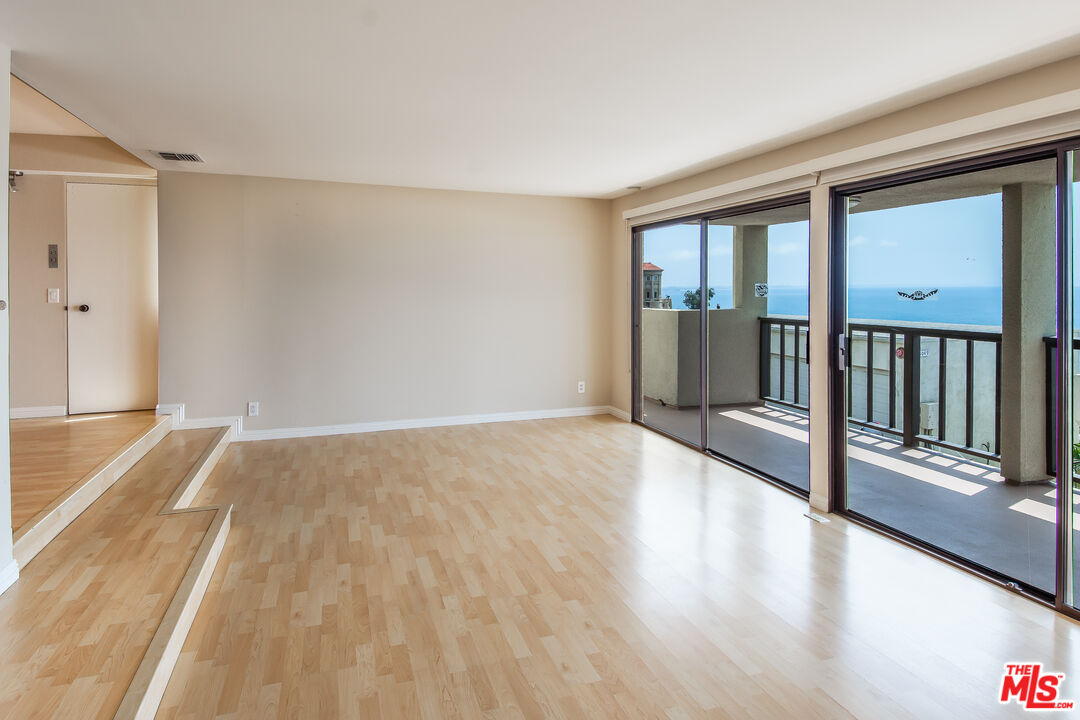 18057 Coastline Drive, Unit 5 Malibu, CA 90265 - Photo 4 of 20 a view of a room with wooden floor and windows