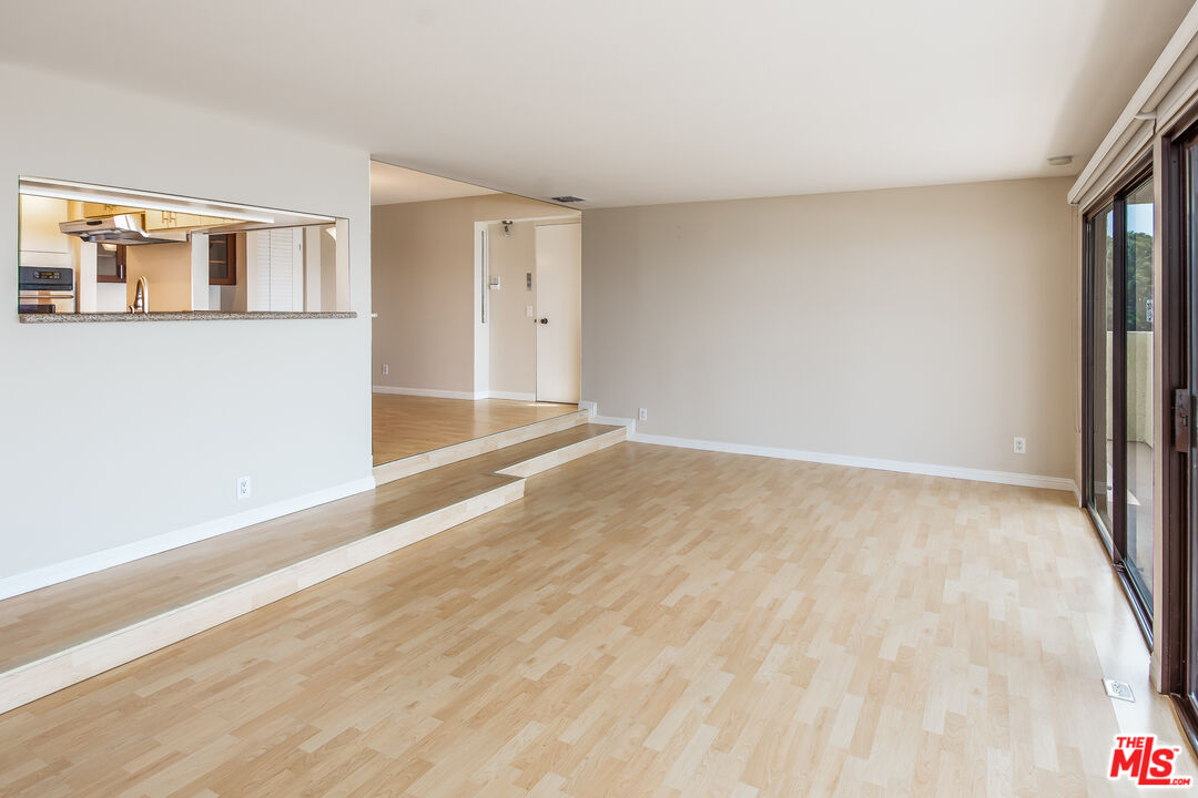 18057 Coastline Drive, Unit 5 Malibu, CA 90265 - Photo 5 of 20 a view of an empty room with wooden floor and a window
