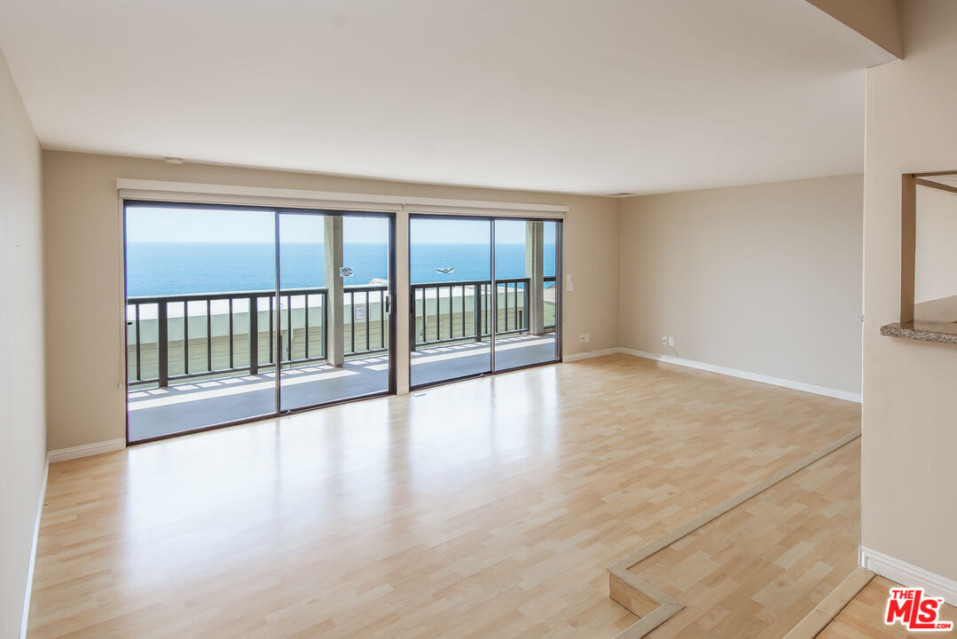 18057 Coastline Drive, Unit 5 Malibu, CA 90265 - Photo 6 of 20 wooden floor in an empty room with a window