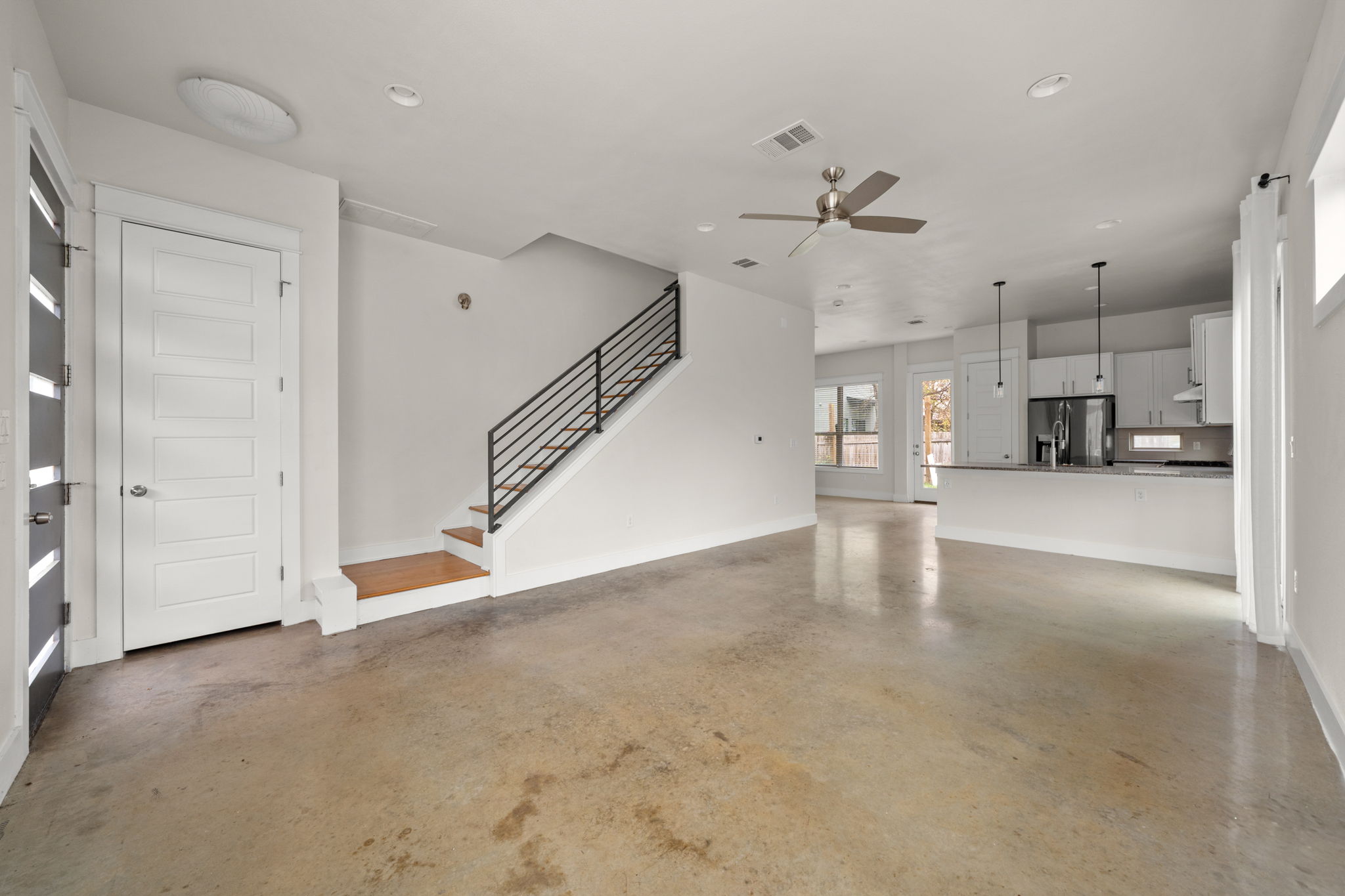 1160 Nickols Avenue, Unit A Austin, TX 78721 - Photo 7 of 40 Unfurnished living room with stairs, concrete floors, a ceiling fan, and recessed lighting