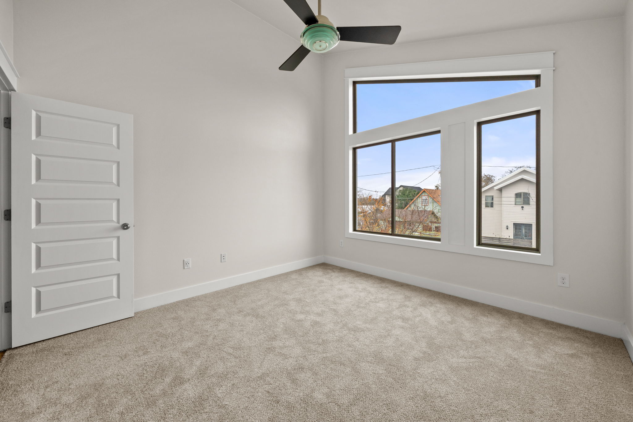 1160 Nickols Avenue, Unit A Austin, TX 78721 - Photo 11 of 40 Empty room with light colored carpet and a ceiling fan