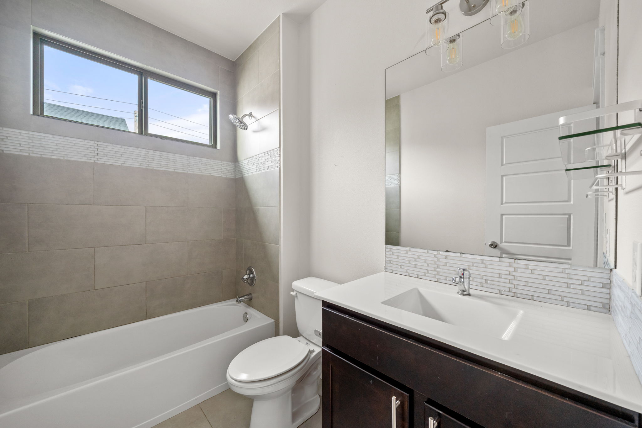 1160 Nickols Avenue, Unit A Austin, TX 78721 - Photo 13 of 40 Full bath featuring shower / bath combination, vanity, backsplash, and light tile patterned flooring