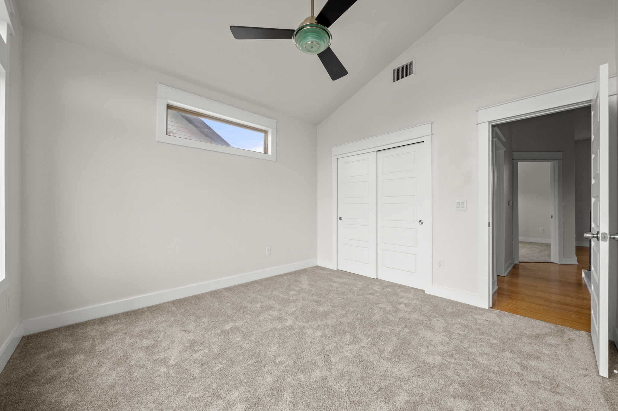 1160 Nickols Avenue, Unit A Austin, TX 78721 - Photo 14 of 40 Unfurnished bedroom featuring light carpet, high vaulted ceiling, a closet, and a ceiling fan